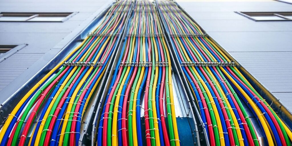 Fiação colorida em tubulação industrial, destacando sistemas de controle e automação em instalações elétricas.